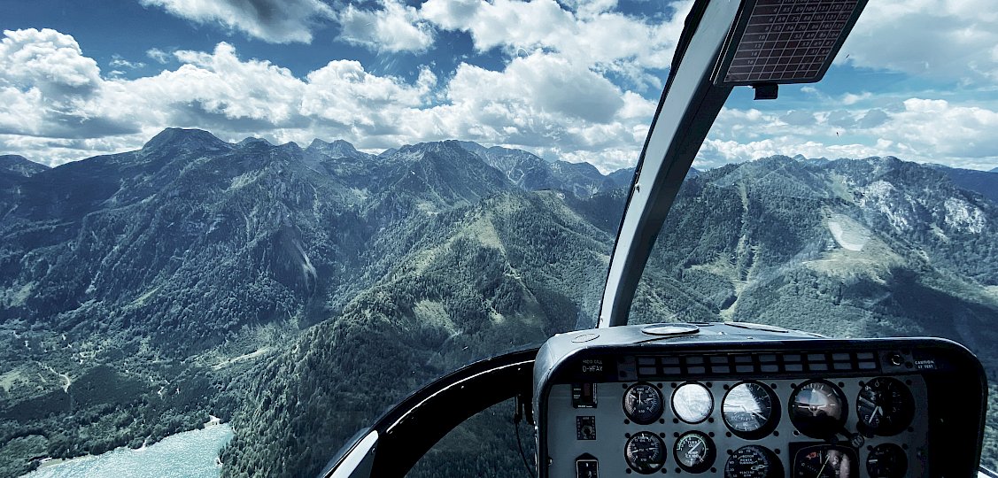 Ausblick aus Hubschrauber-Cockpit auf Berge