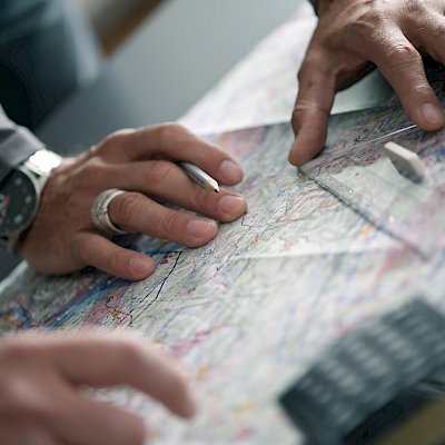 Männliche Hände auf einer Karte zur Flugplanung